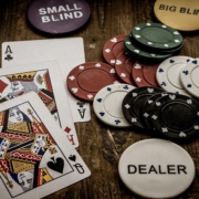 Ace and Queen of spade cards with casino chips on table