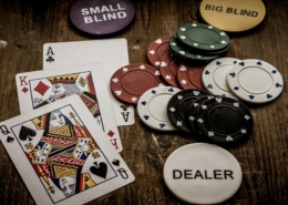 Ace and Queen of spade cards with casino chips on table
