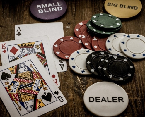 Ace and Queen of spade cards with casino chips on table
