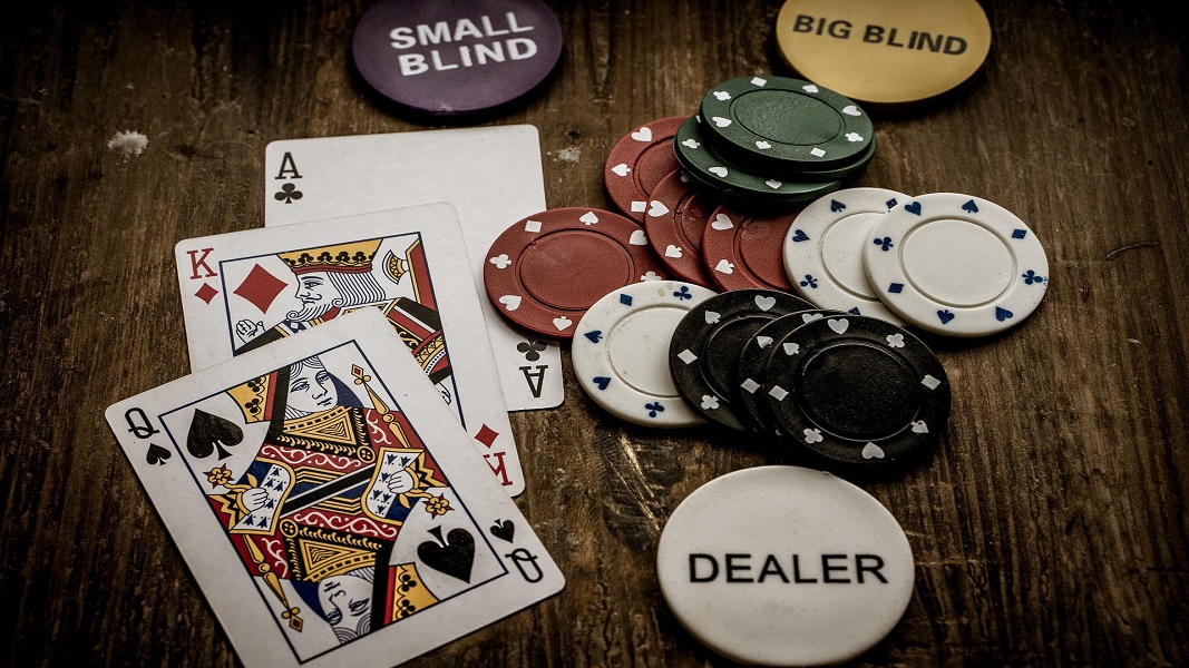 Ace and Queen of spade cards with casino chips on table