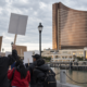 Editorial illustration for Encore Boston Harbor Strike Reaches Day 40 as Contract Talks Continue
